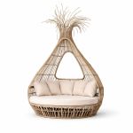 Bohemian wicker bed with teardrop canopy frame and cream cushion, statement lounge bed rental for boho weddings and outdoor events.