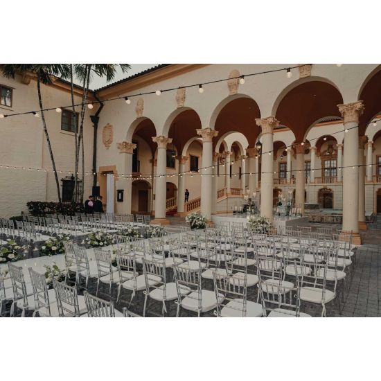 Clear resin Chiavari chair with black cushioned seat, spindled backrest and slim frame for elegant event seating