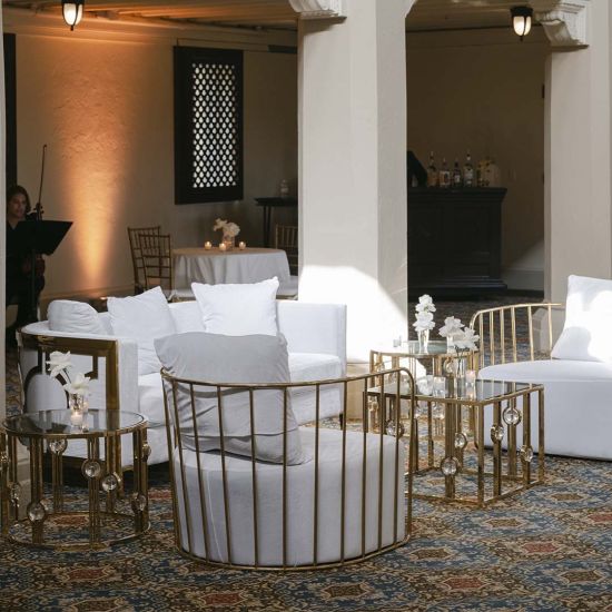 Square gold coffee table with a clear glass top and decorative vertical rods featuring crystal-style spheres for a glamorous modern look