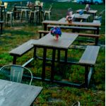 Wood picnic table with attached benches and black aluminum frame, rustic outdoor table rental for events, festivals, and gatherings.