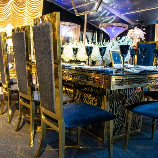Gold Art Deco dining table 48″ × 96″ with rectangular mirrored top and bold geometric base, perfect for luxury event dining and upscale receptions