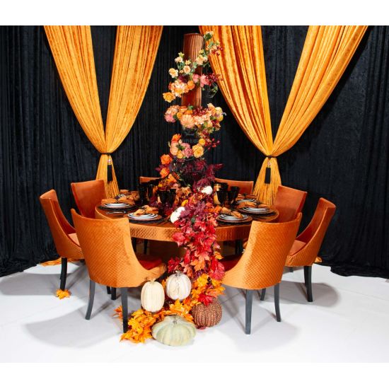 Black-leg Isabello chair with orange velvet cushioned seat and tall modern backrest, premium event dining seating