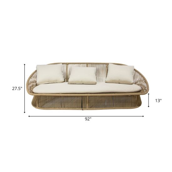 Spade sofa with round woven wicker frame and cream cushions, relaxed boho lounge sofa rental for weddings and outdoor events.