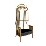 Gold dome cage armchair with vertical gold metal bars and black velvet seat cushion, modern luxury lounge chair for weddings and events.