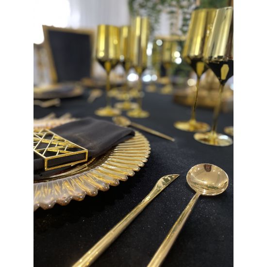 Geometric napkin holder with gold metal open-frame cube design holding a folded white cloth napkin, modern accent for event table settings