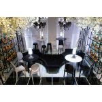 Black ghost resin bar stool with oval tinted backrest, matte black seat and integrated foot-rail, sleek contemporary event bar seating