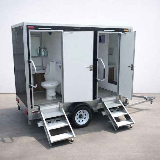 Luxury Portable RestroomBlack portable restroom trailer with dual doors, aluminum steps, diamond plate trim and tow hitch parked outdoors beside a swimming pool