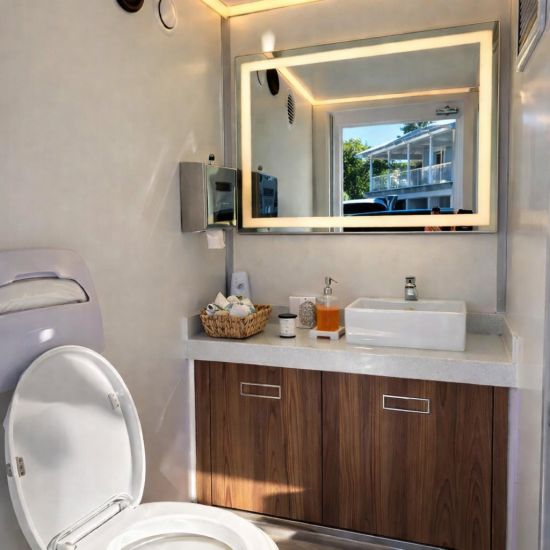 Luxury Portable RestroomBlack portable restroom trailer with dual doors, aluminum steps, diamond plate trim and tow hitch parked outdoors beside a swimming pool