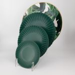 Emerald green petal-rim dessert plate with radiating ridges and a smooth center, small round plate on a white background