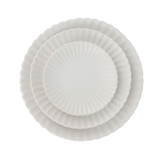 White petal-rim dessert plate with radiating ridges and a smooth center, small round plate on a white background