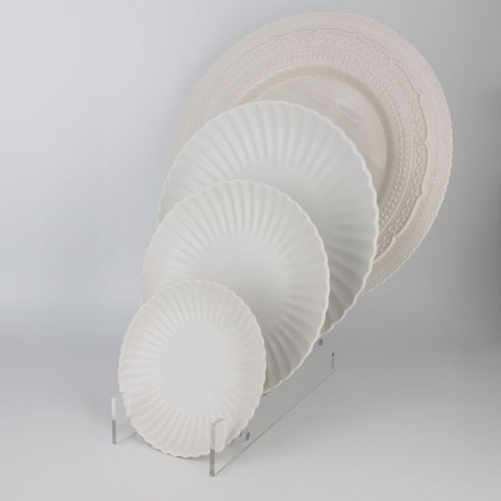 White petal-rim dessert plate with radiating ridges and a smooth center, small round plate on a white background