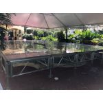 Clear acrylic stage platform 2x4 with metal truss base, modular riser for events, runway staging, and performances.