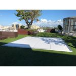 Mocha rattan armless chair with white cushion, modular outdoor sectional seating piece rental for weddings and lounge events.