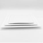 White square dinner plate with wide raised rim and angled corners, large square plate on a white background