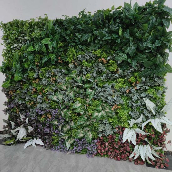 Lush green foliage wall backdrop with mixed leaves and floral accents, garden-style photo backdrop panel for weddings and events.