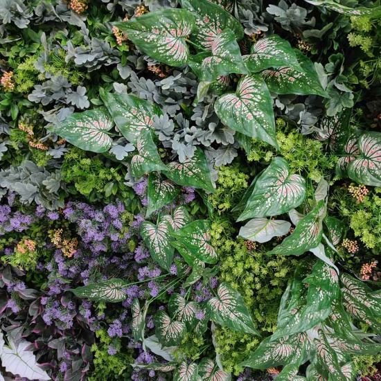 Lush green foliage wall backdrop with mixed leaves and floral accents, garden-style photo backdrop panel for weddings and events.