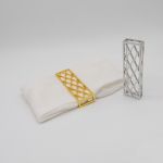 Lattice napkin holder with open metal grid design securing a folded white cloth napkin, modern table accessory for weddings and event décor