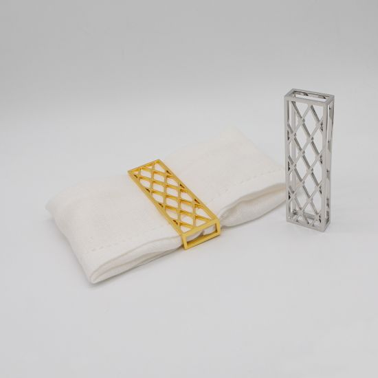 Lattice napkin holder with open metal grid design securing a folded white cloth napkin, modern table accessory for weddings and event décor