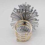 Stardust napkin ring with sparkling rhinestone-style details securing a folded white cloth napkin, glamorous accessory for wedding and event tables