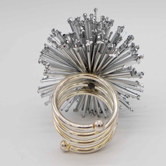 Stardust napkin ring with sparkling rhinestone-style details securing a folded white cloth napkin, glamorous accessory for wedding and event tables