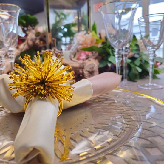 Stardust napkin ring with sparkling rhinestone-style details securing a folded white cloth napkin, glamorous accessory for wedding and event tables