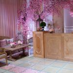 Natural wood colonial-style pedestal column with paneled cabinet-like design, rustic event decor display stand for weddings and props.