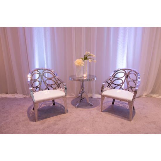 Silver reflective Butterfly Reflection armchair with circular cutout backrest and white cushioned seat, modern event lounge chair rental