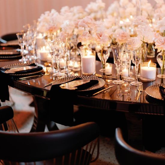 Reflection Serpentine gold table with stainless steel top, curved serpentine dining table with gold legs for luxury event rentals and décor.