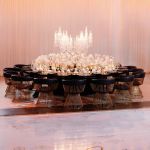 Reflection Serpentine gold table with stainless steel top, curved serpentine dining table with gold legs for luxury event rentals and décor.