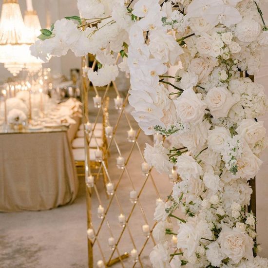 Gold candle wall backdrop with diamond lattice grid and freestanding base, elegant wedding decor display for candles and event styling.