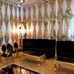 Gold laser-cut wall panel with repeating art deco geometric pattern, luxe event backdrop wall for weddings, stages, and photo ops.